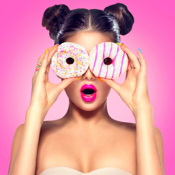 Beauty model girl taking colorful donuts. Dieting concept